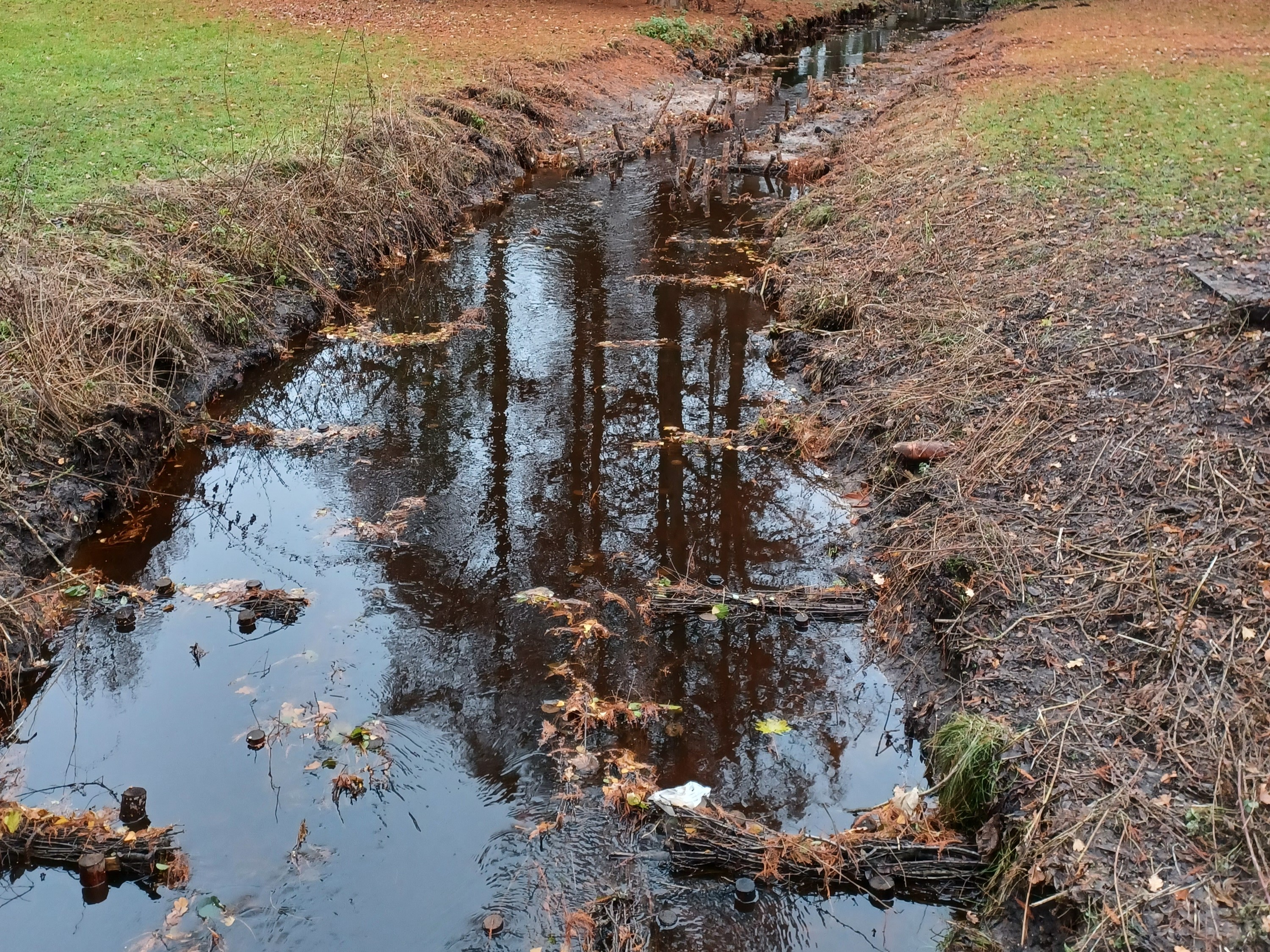 Wasserlauf mit Reisigbündeln