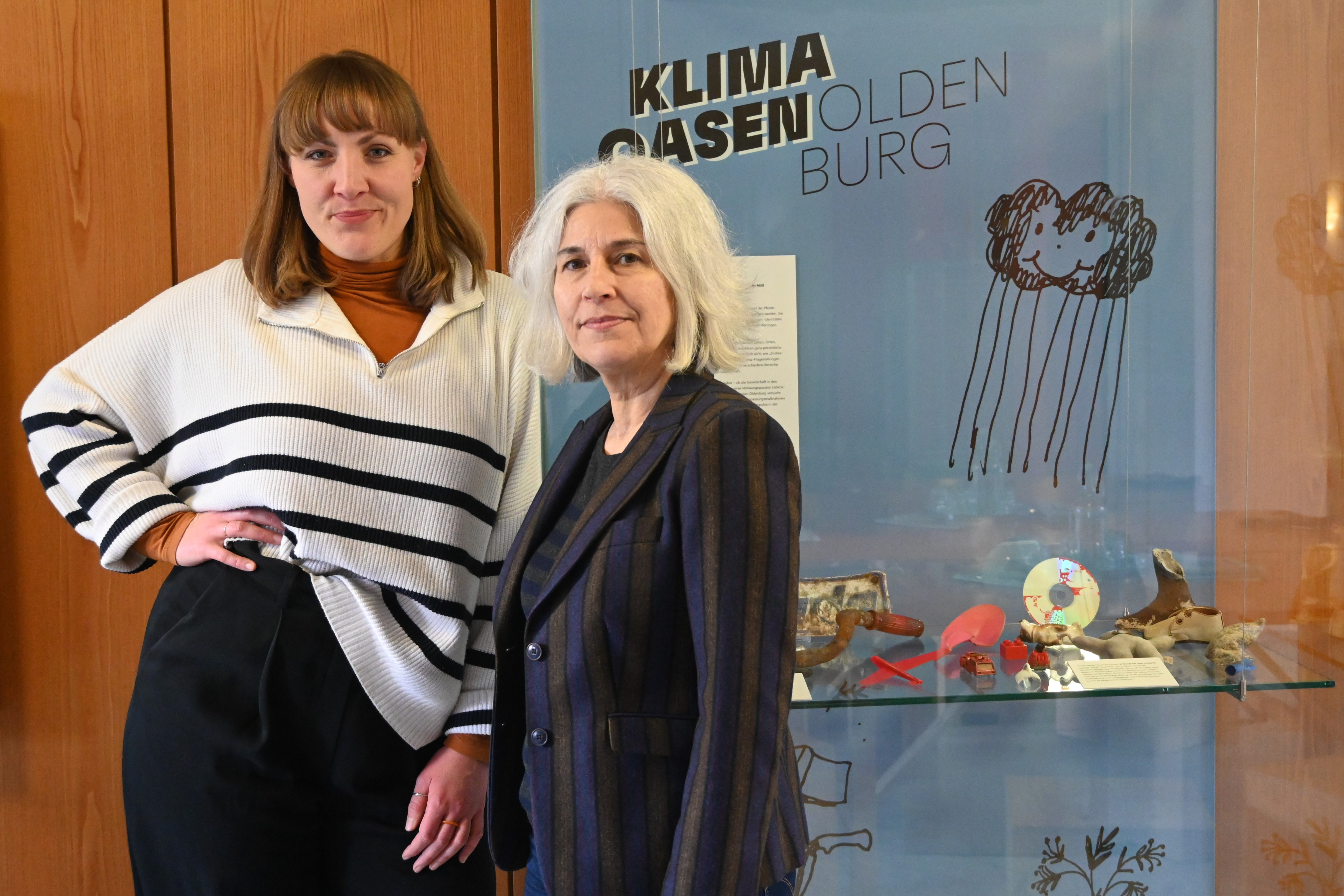 Saskia Benthack und Ursula Warnke stehen vor einer Vitrine mit Fundstücken wie einer CD