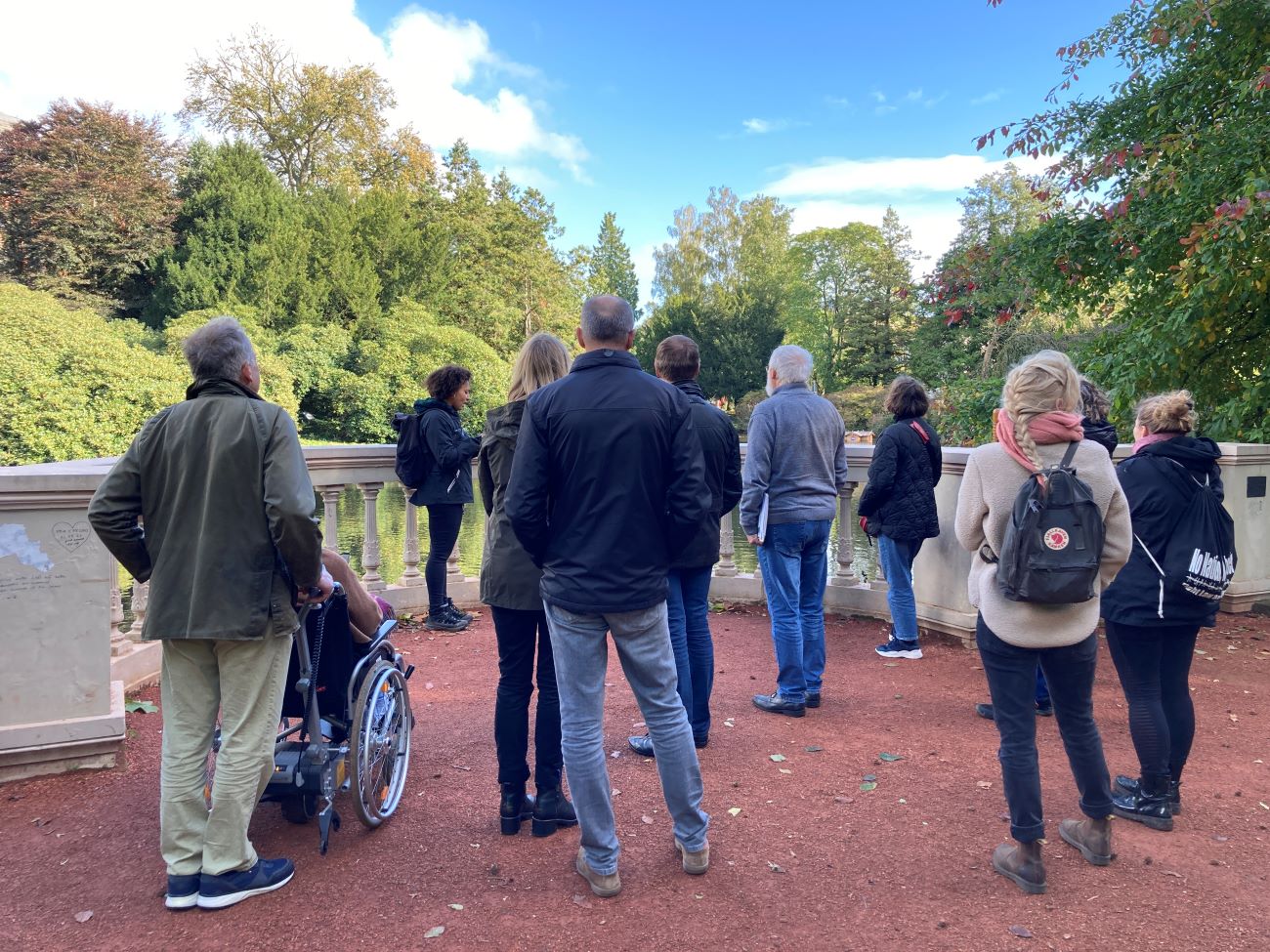 Chioma Ndukwe und eine bunte Menschenmenge im Schlossgarten mit Blick auf den Schlossteich